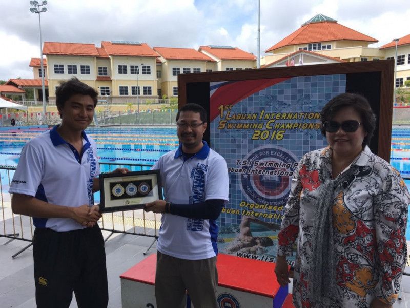 Souvenir presentation by Clement David to En Wan Ahmad Sanusi, accompanied by Pn Zainab Principal